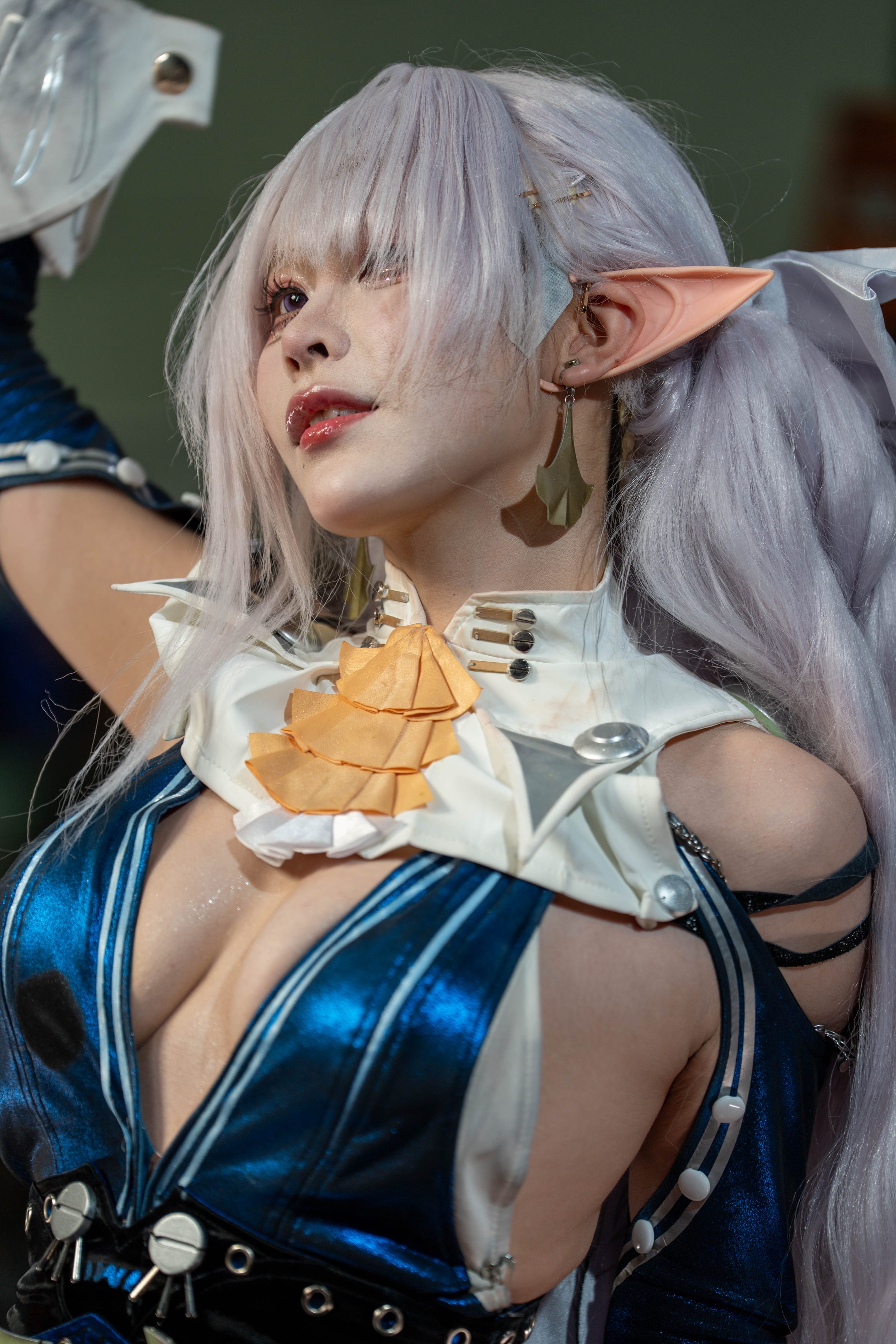 Close portrait of a cosplayer in blue and white armor against the wall of vintage televisions
